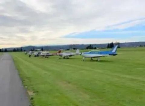 Airplanes lined up on a grass parking area