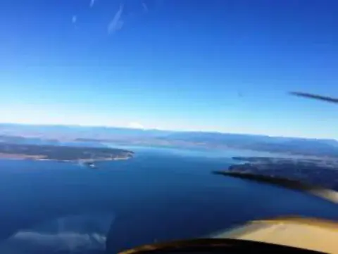 An aerial view of a bay and coastline from the cockpit
