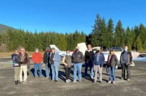 A group of members standing on the ramp near the trees