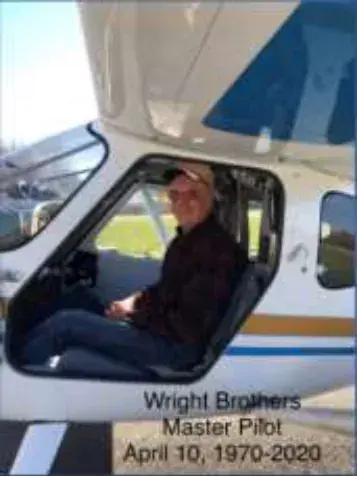 A pilot in the cockpit of a white airplane with a Wright Brothers Master Pilot caption