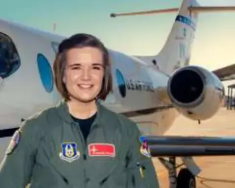 A young woman in a flight suit in front of a business jet