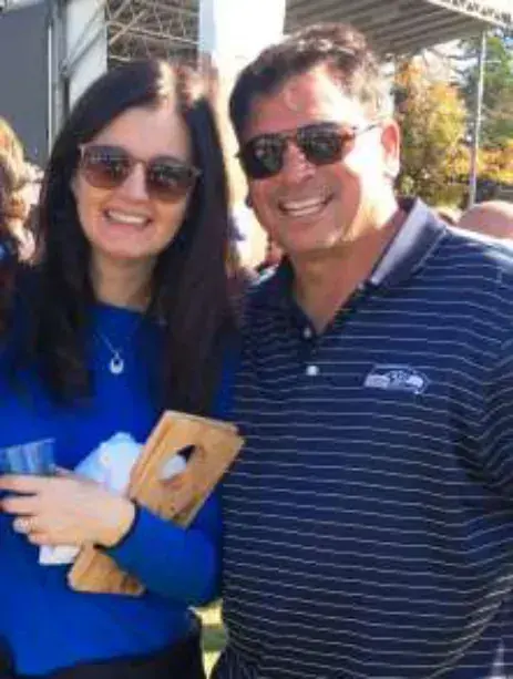 A smiling woman and man in sunglasses posing together outdoors