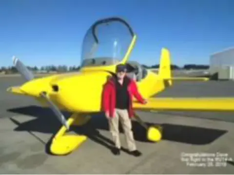 A man standing by a yellow homebuilt airplane with its canopy open