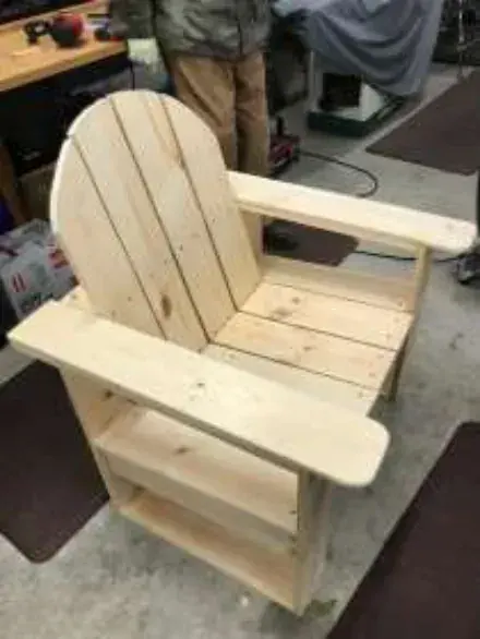 A wooden Adirondack chair in a workshop