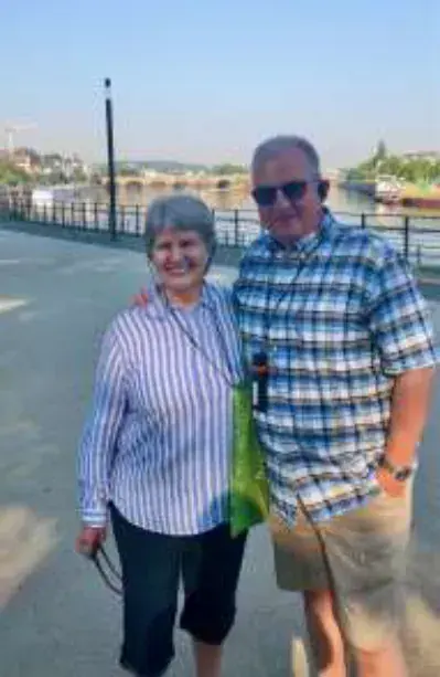 A couple standing on a waterfront walkway