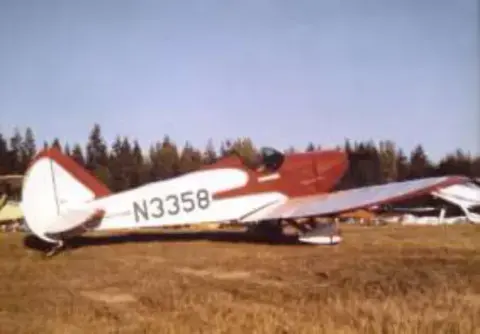 A red and white FlyBaby on a grass field