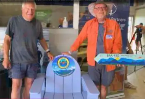 Two men posing with an Adirondack chair at AirVenture