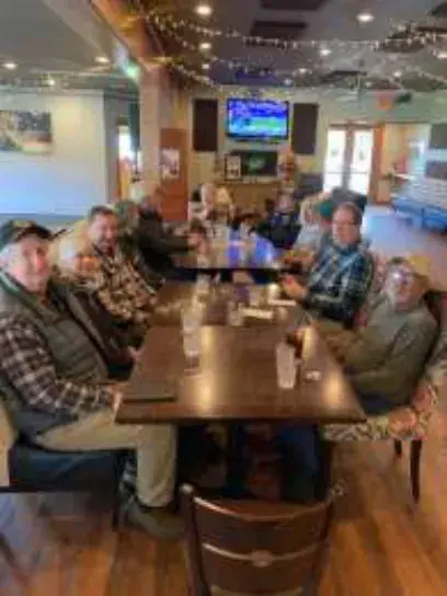 Members seated at a long restaurant table