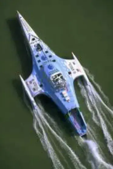 An aerial view of a futuristic powerboat speeding through water
