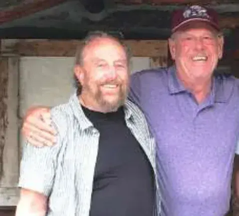 Two smiling men posing together