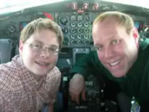 Two men smiling in the cockpit of an airliner
