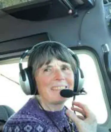 A woman wearing a headset in a cockpit