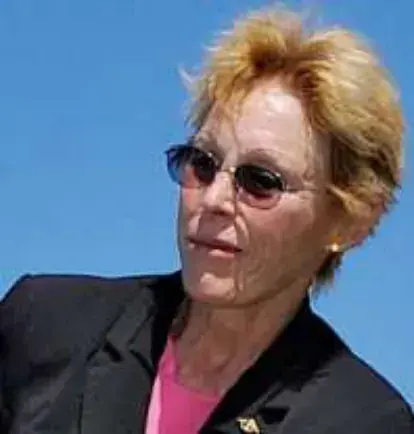 Ginny in sunglasses against a blue sky