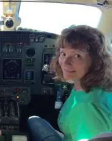 Jane seated at the controls in a jet cockpit