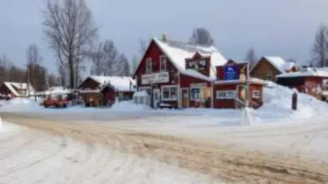 Snow-covered red lodge buildings in Alaska