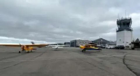 Small airplanes on the ramp near a control tower