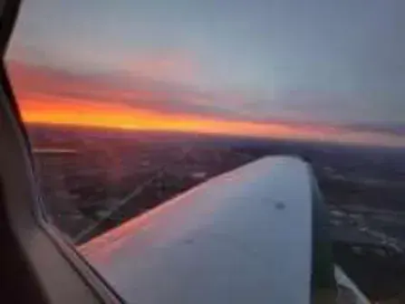 A sunset seen over an airplane wing