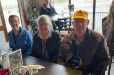 Three people seated at a restaurant table