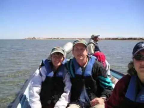 Several people in life vests riding in a small boat