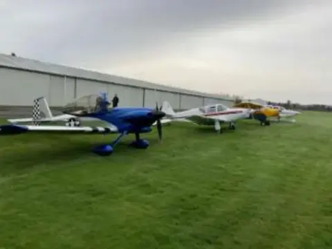 Airplanes parked on grass at the fly-out