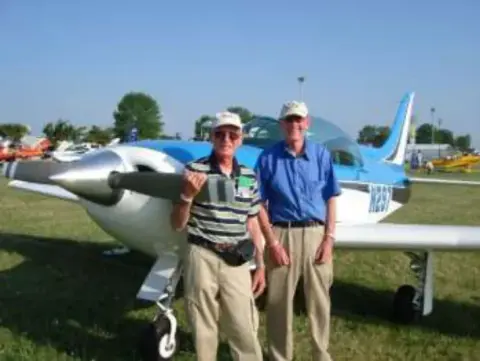 Two men standing in front of a white homebuilt airplane