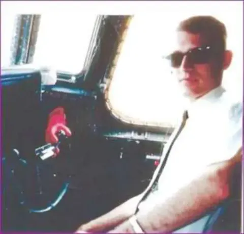 An old photo of a young man in sunglasses in a cockpit