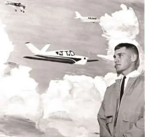 A black and white photo of a man with jet airplanes in flight behind him