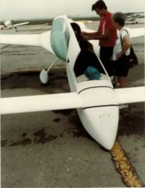 A man next to the canopy of a white composite airplane