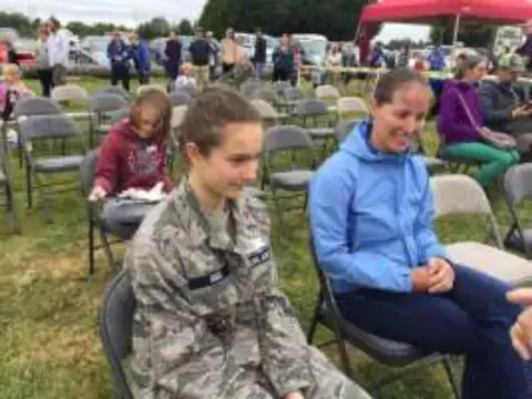 Young people and adults seated in chairs at the rally