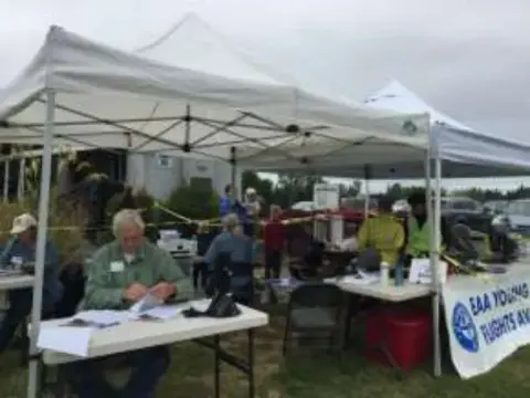 Volunteers at a registration table under a tent