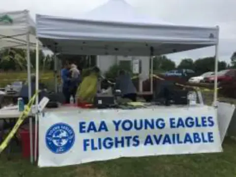 A Young Eagles registration table under a tent with a banner