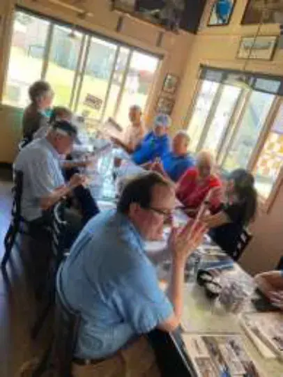 Members seated at a long table inside the cafe