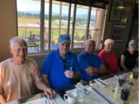 Members seated at a table by the cafe windows