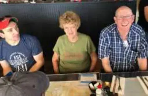 Three people seated at a restaurant table