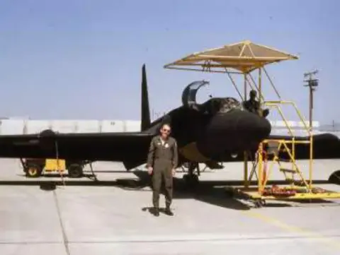 A pilot standing beside a U-2 spy plane on the ramp