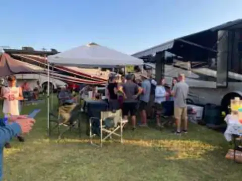 Chapter members gathered under a canopy at their campsite