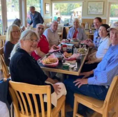 Members seated at a long table in a restaurant