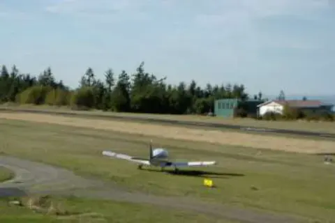 A small airplane on a grass runway