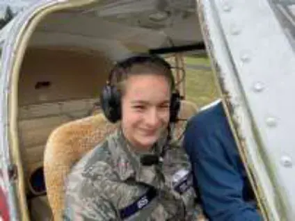 A young cadet in a headset seated in a cockpit