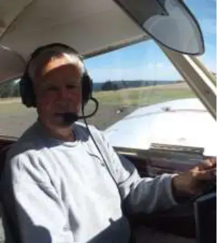 A man in a headset in the cockpit