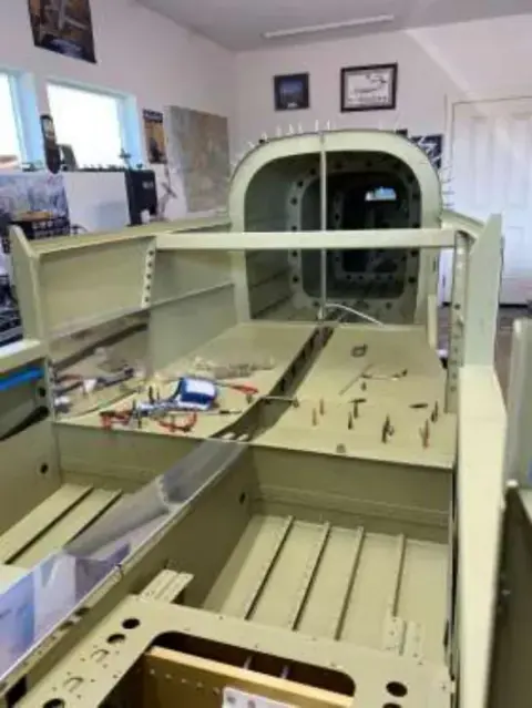 An airplane fuselage under construction in a workshop