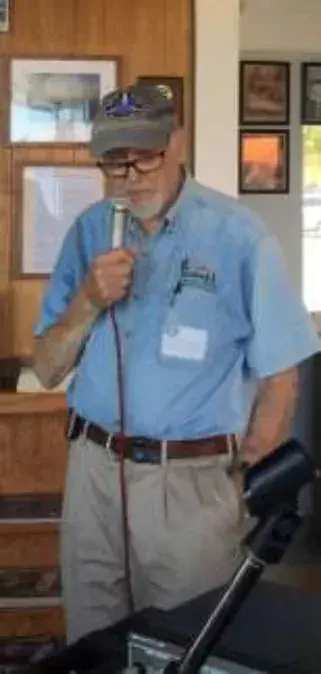 A man in a name tag speaking into a microphone