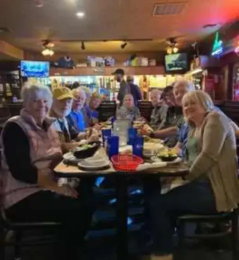 Members seated around a restaurant table