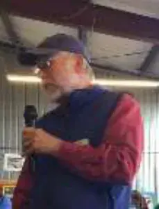 A man in a cap speaking into a microphone