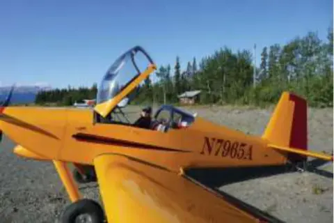 A yellow homebuilt airplane with its canopy open