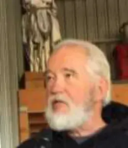 A white-bearded man in a dark sweatshirt