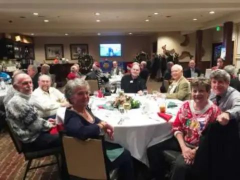 A full table of members posing for the camera
