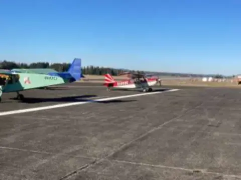 Small airplanes parked on the ramp under a cloudy sky