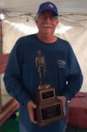A man holding a trophy at an indoor event