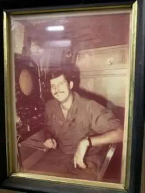 A framed old photo of a man seated at a desk